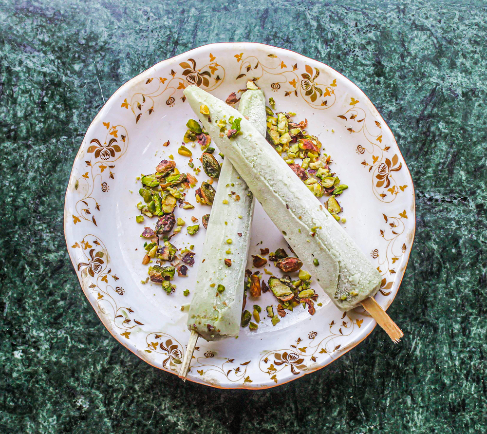 Pistachio ice cream sticks on decorative plate.