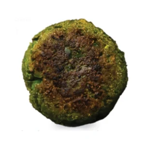 A cooked green falafel patty with a browned surface.