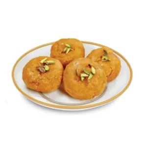 Plate of Indian sweet gulab jamun garnished with nuts.