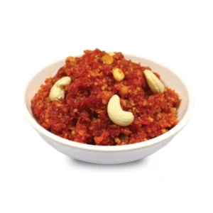 Bowl of spicy red chutney garnished with cashew nuts.