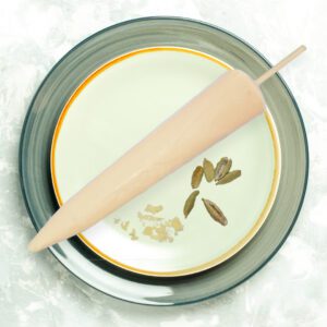 A rolling pin resting on a decorative plate with a floral design.
